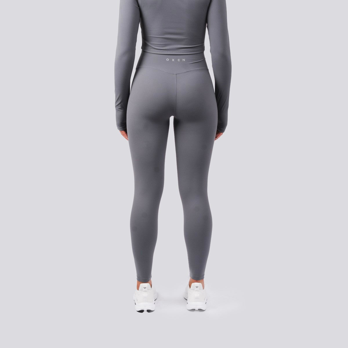 Person wearing a gray athletic outfit on a light gray background