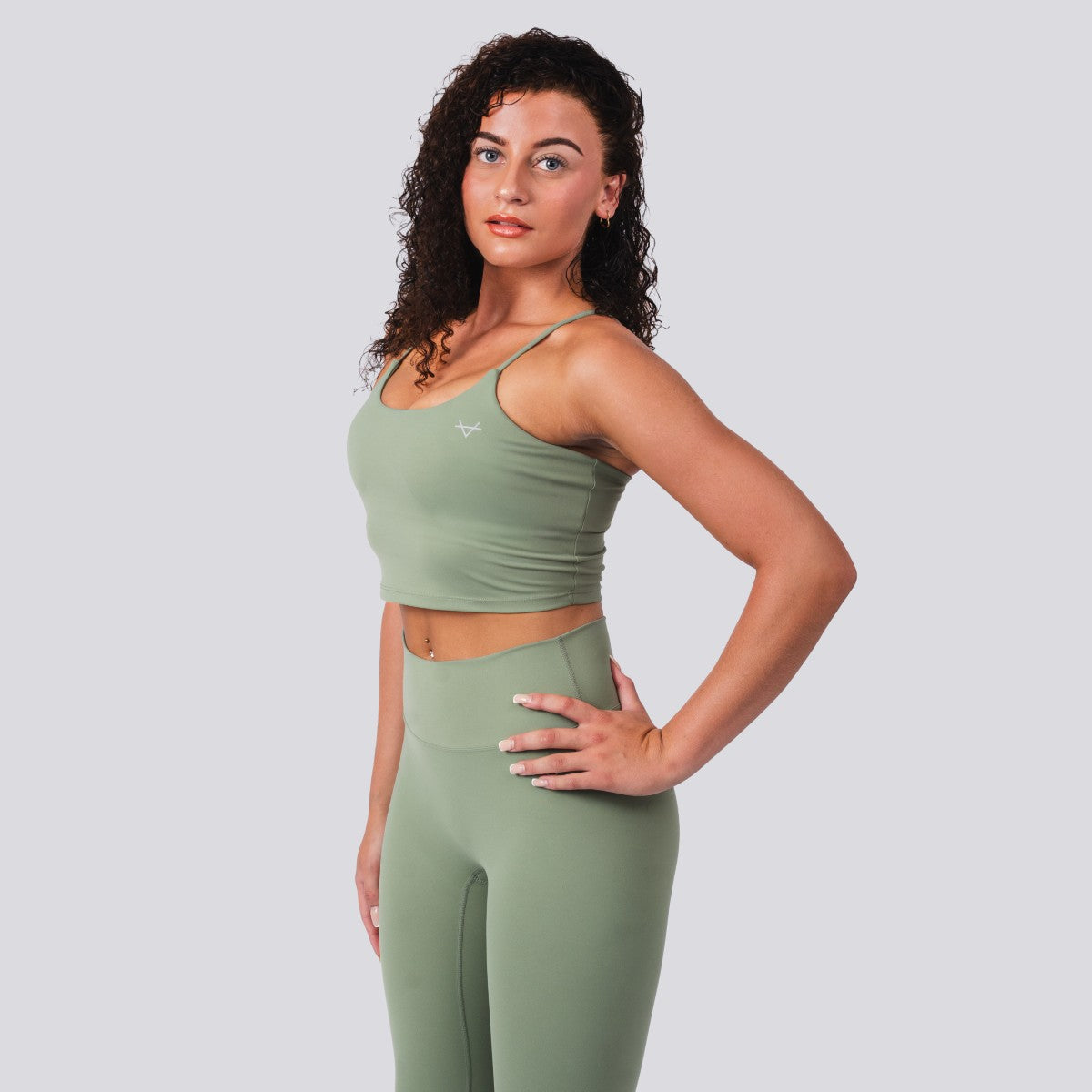 Woman wearing a green athletic outfit on a plain background