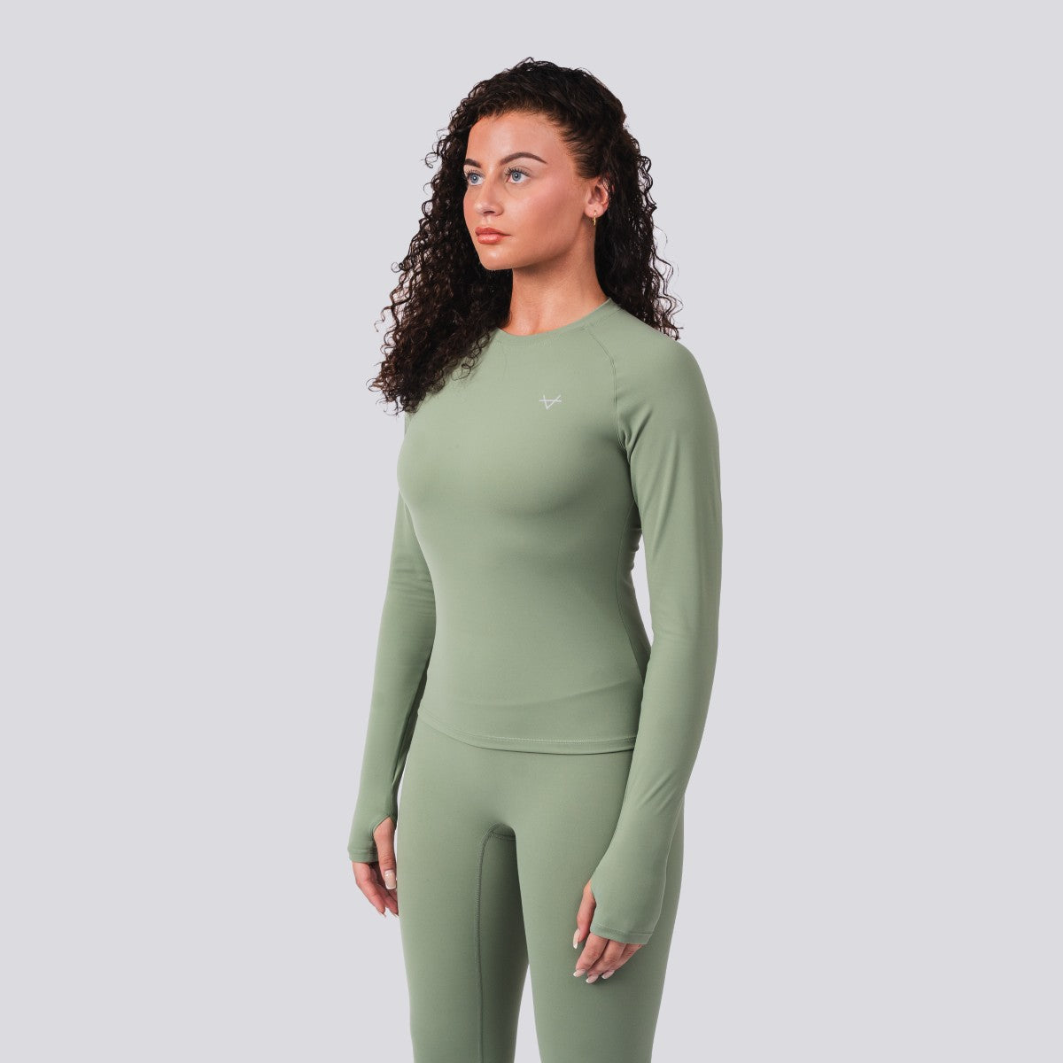 Woman wearing a green athletic outfit on a light gray background