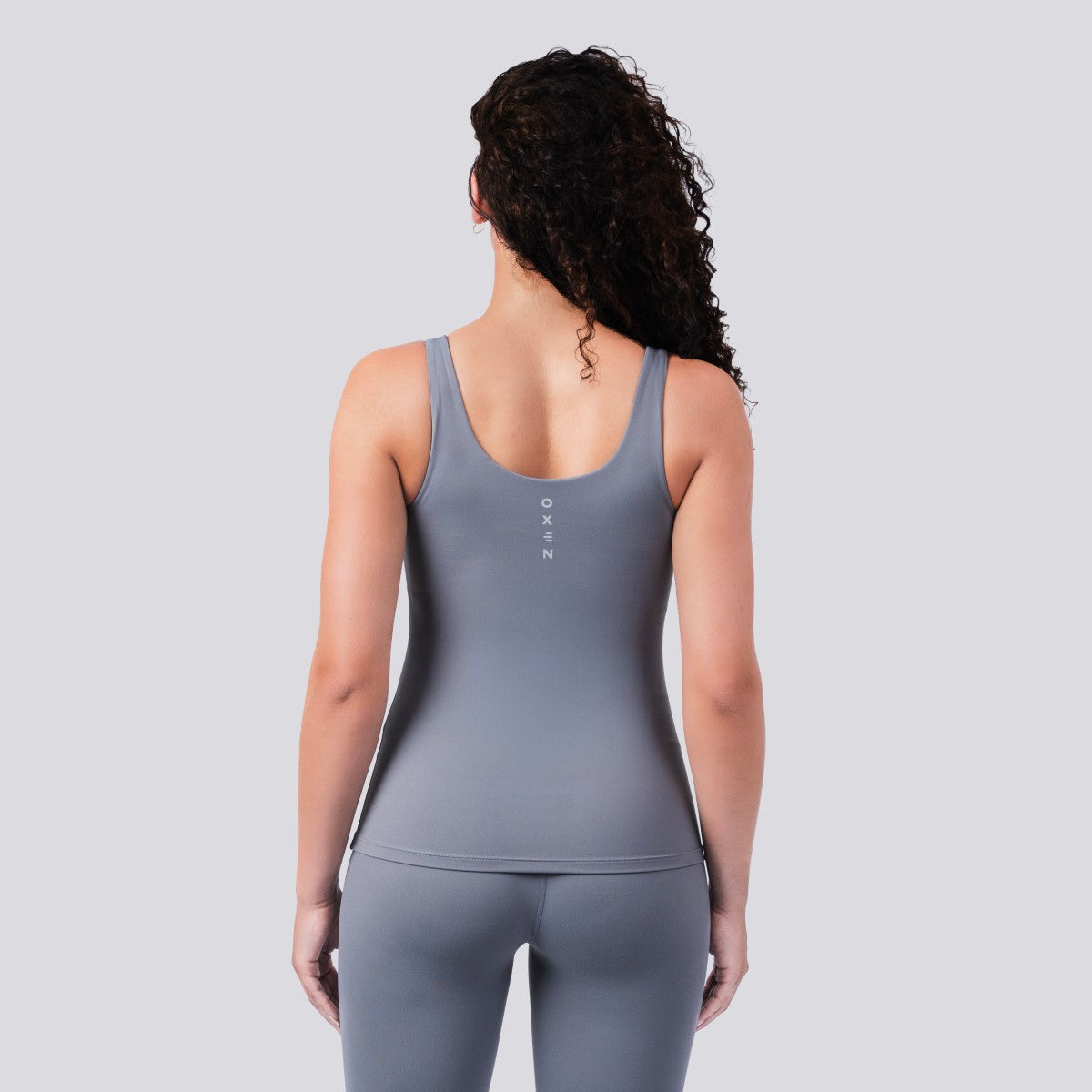 Model wearing Oxen Women’s Endure Sculpt Tank in Fossil grey, back view.
