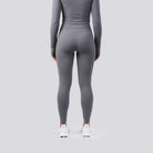 Person wearing a gray athletic outfit on a light gray background