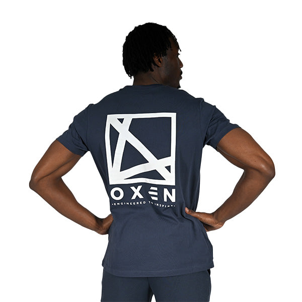 Person wearing a navy blue t-shirt with a white logo on the back, standing against a white background.