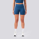 Person wearing blue athletic shorts on a gray background