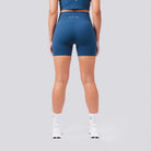 Person wearing blue athletic shorts on a gray background