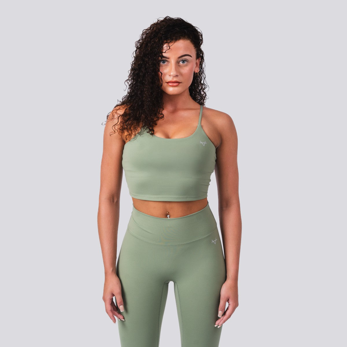 Woman wearing a green athletic outfit on a light gray background