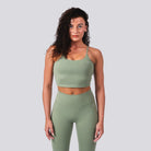 Woman wearing a green athletic outfit on a light gray background