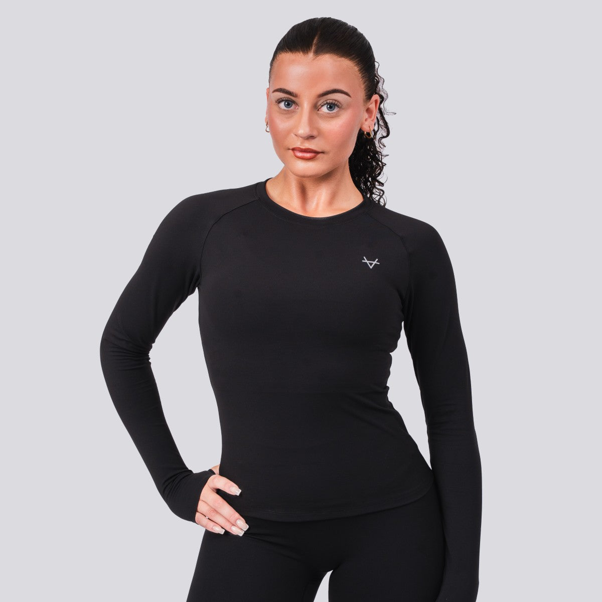 Woman wearing a black long-sleeve athletic shirt on a light gray background