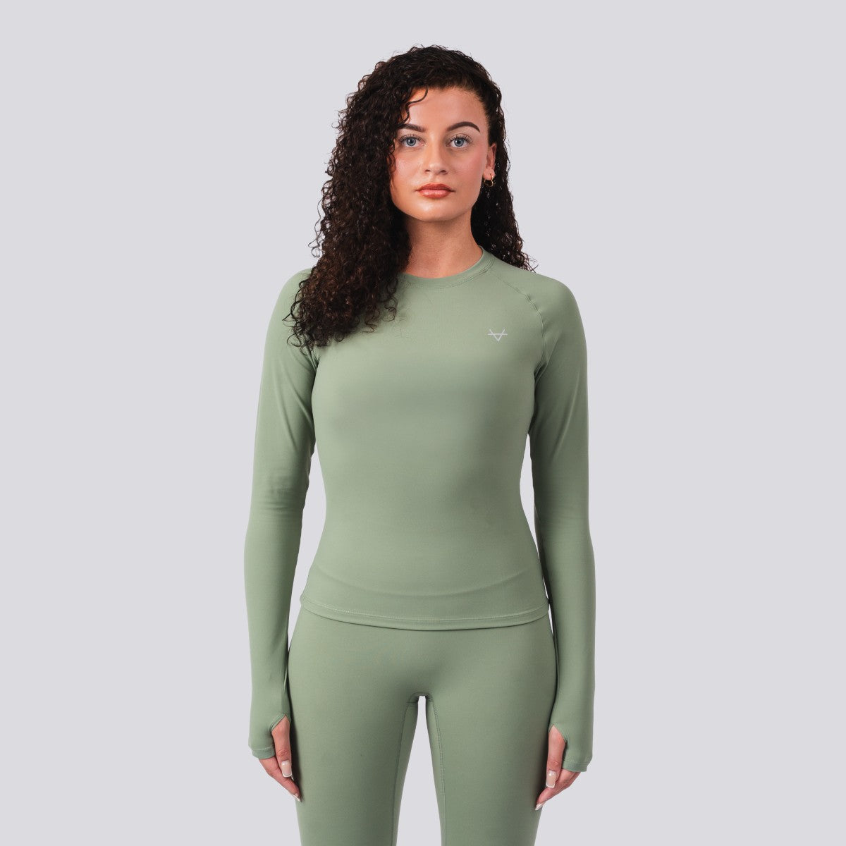 Woman wearing a green athletic outfit on a light gray background