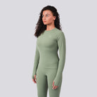 Woman wearing a green athletic outfit on a light gray background