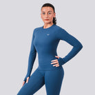 Woman wearing a blue athletic outfit with a logo on a gray background