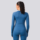 Person wearing a blue athletic outfit with a visible brand logo on a gray background