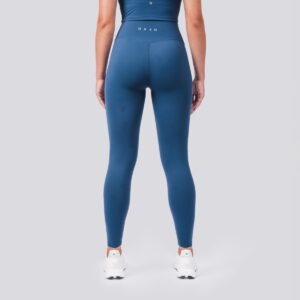 Person wearing blue athletic leggings and top on a light gray background